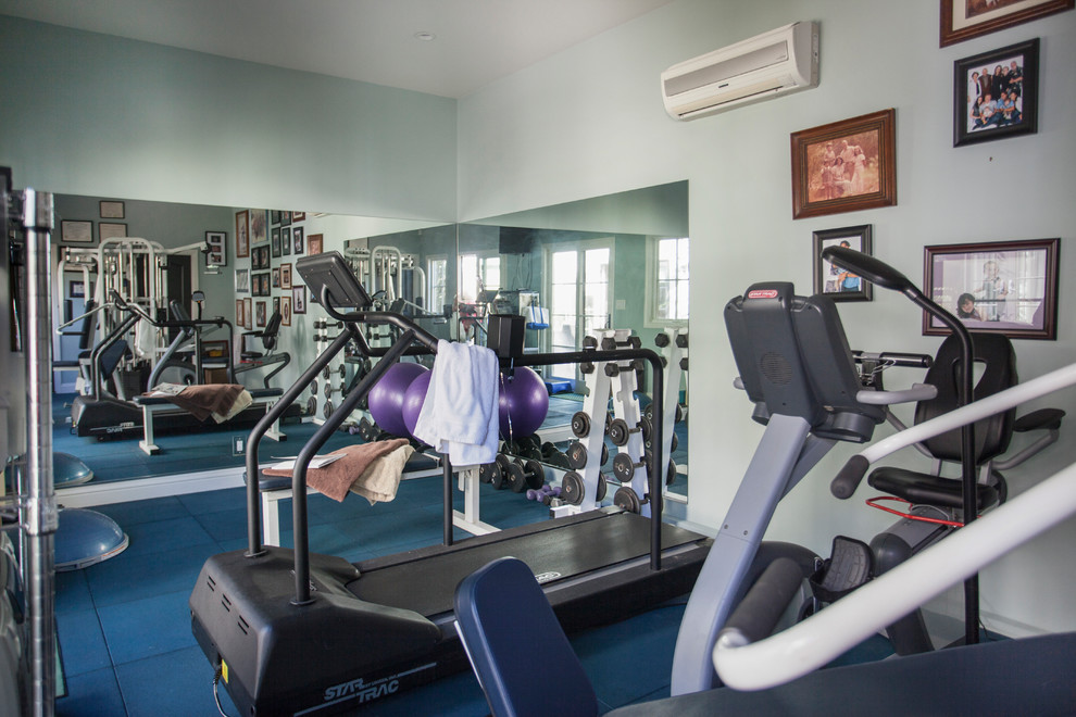 Imagen de gimnasio multiusos mediterráneo de tamaño medio con paredes verdes y suelo azul