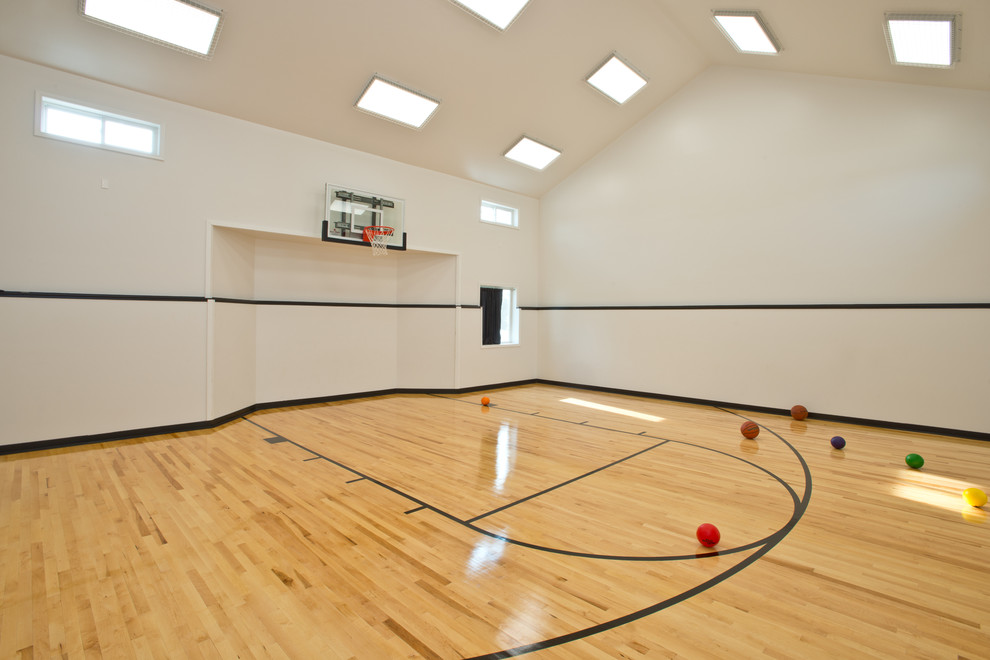 Cette image montre un terrain de sport intérieur traditionnel avec un mur blanc et parquet clair.