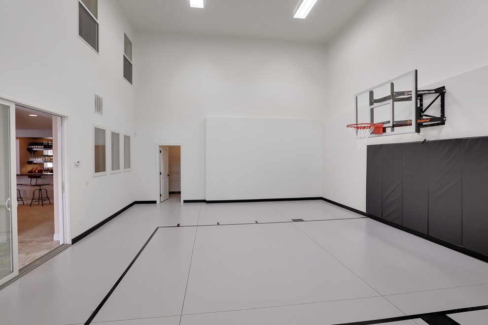 Großer Klassischer Fitnessraum mit Indoor-Sportplatz, weißer Wandfarbe und Betonboden in Minneapolis