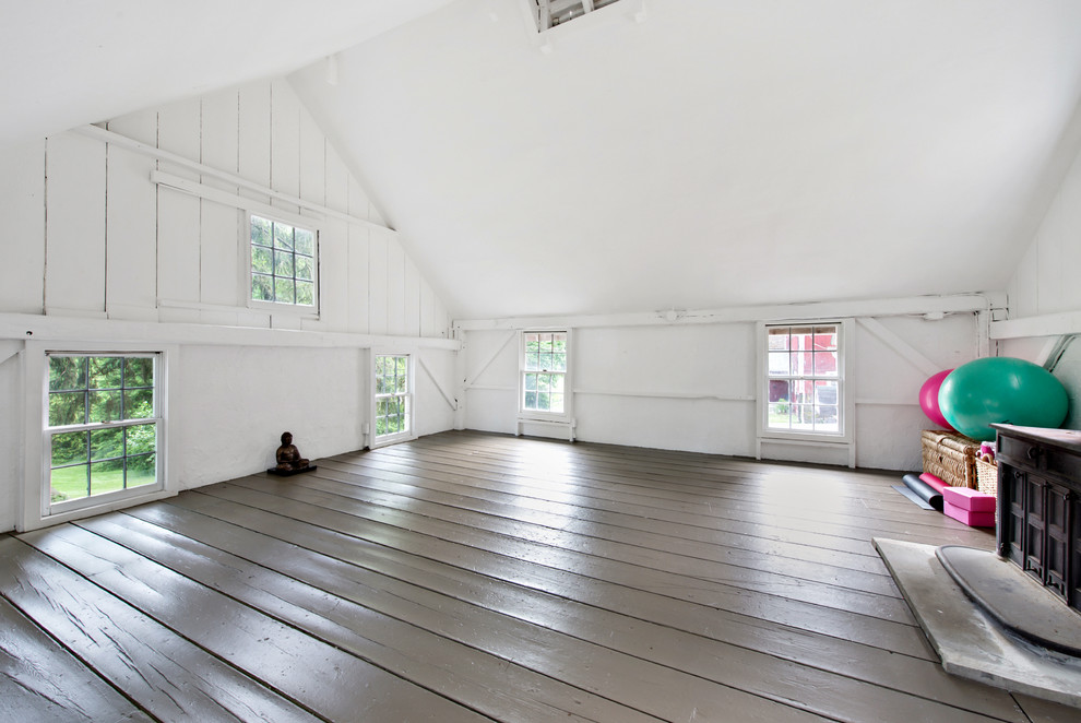 Стильный дизайн: большая йога-студия в стиле кантри с белыми стенами, деревянным полом и серым полом - последний тренд