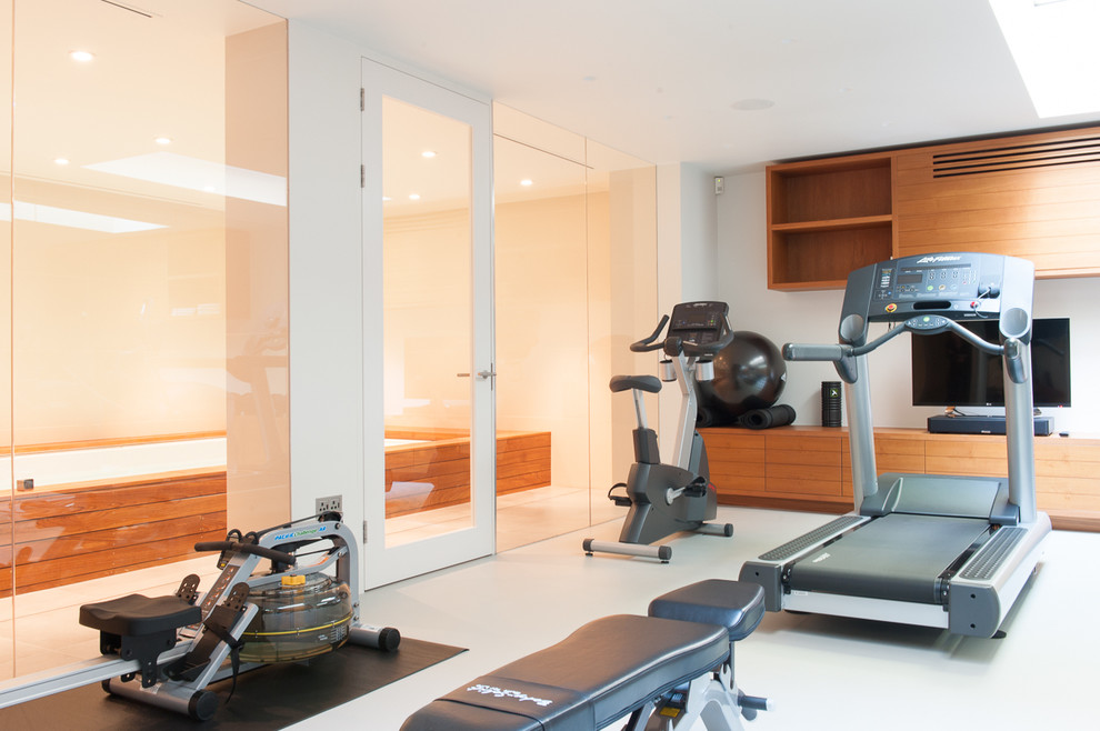 Photo of a contemporary home weight room in London with white floors.