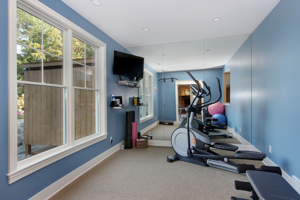 Multifunktionaler Fitnessraum mit blauer Wandfarbe und Teppichboden in Grand Rapids