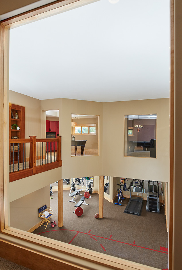 Cette image montre un grand terrain de sport intérieur craftsman avec un mur beige et moquette.