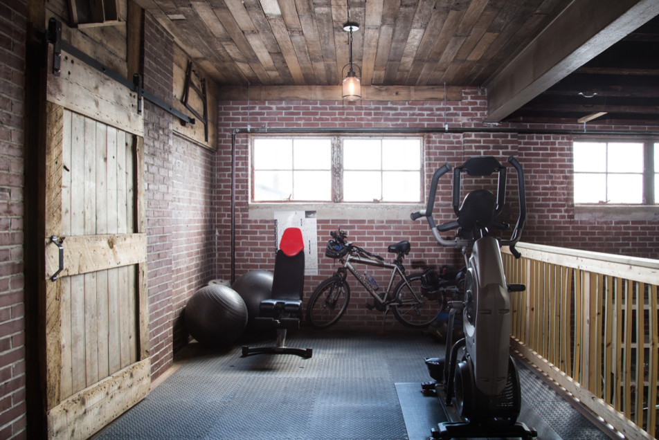 Multiuse home gym - large industrial concrete floor and gray floor multiuse home gym idea in Other with red walls