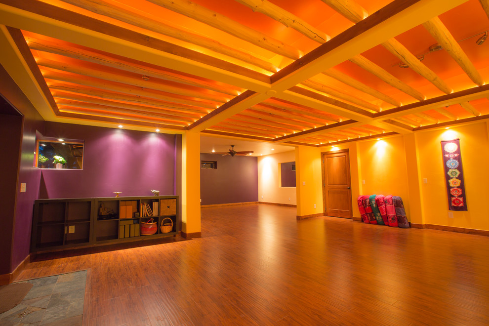 デンバーにある高級な広いラスティックスタイルのおしゃれなヨガスタジオ (紫の壁、無垢フローリング、茶色い床) の写真