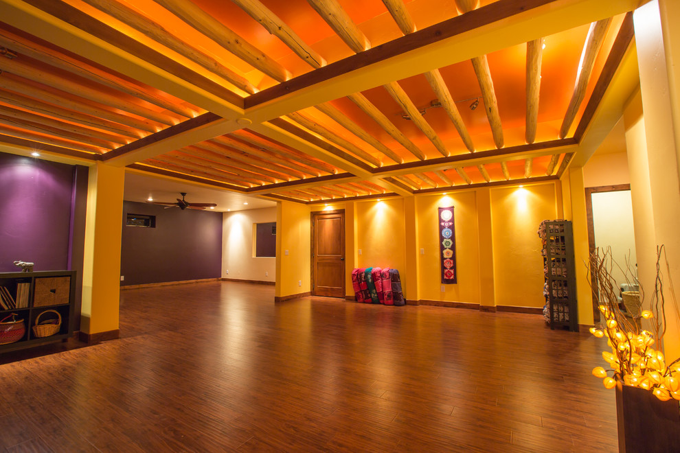 На фото: большая йога-студия в стиле рустика с фиолетовыми стенами, паркетным полом среднего тона и коричневым полом с