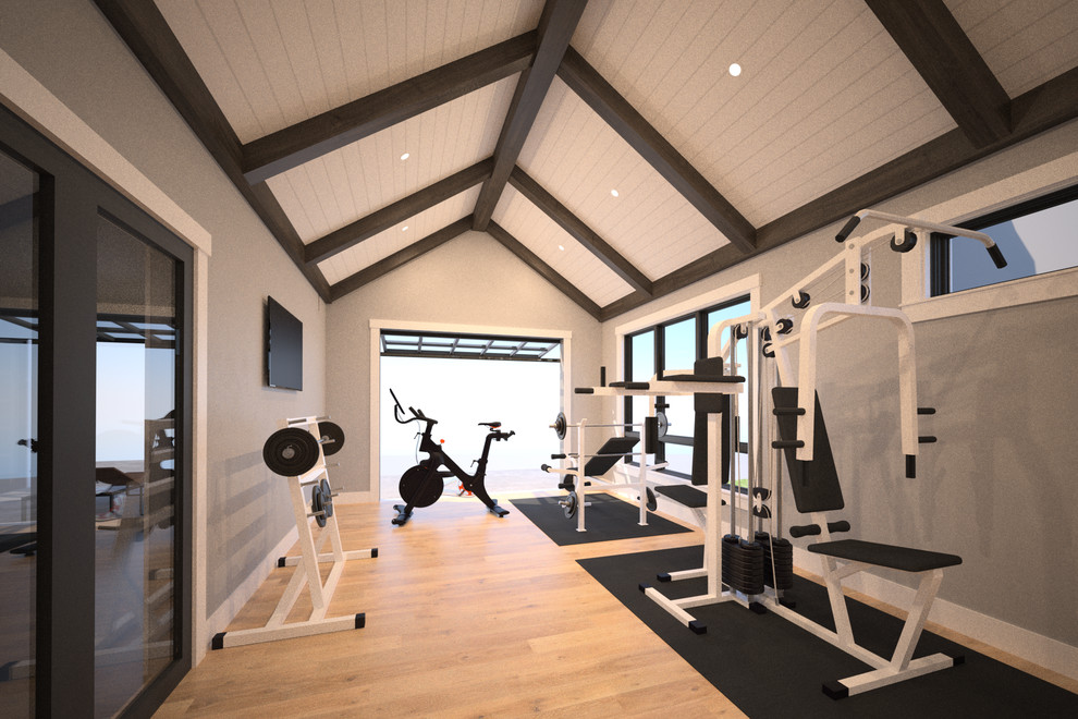 Diseño de sala de pesas contemporánea grande con paredes grises y suelo de madera clara
