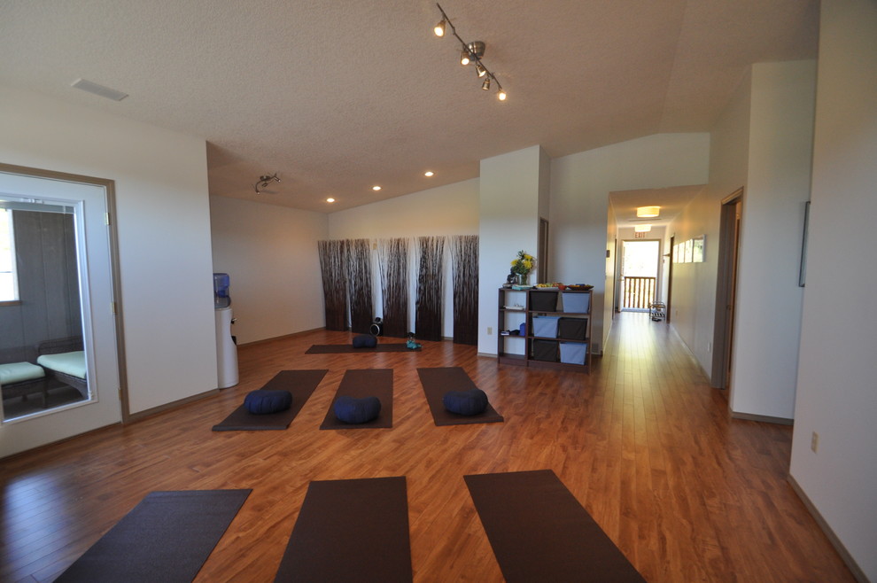 Idee per un piccolo studio yoga contemporaneo con pareti blu e parquet chiaro