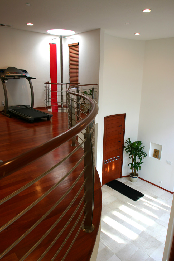 Example of a mid-sized minimalist medium tone wood floor multiuse home gym design in San Francisco with white walls