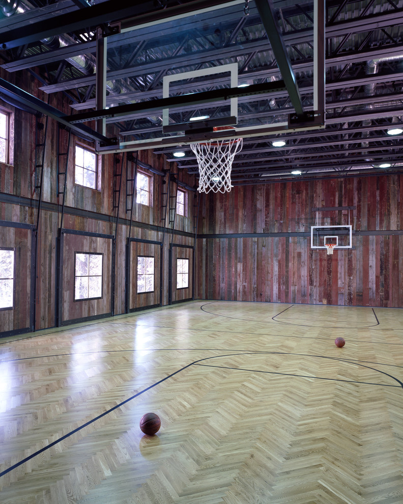 This is an example of an expansive rustic indoor sports court in Denver with brown walls, light hardwood flooring and feature lighting.