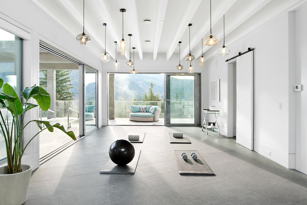 Réalisation d'un studio de yoga design avec un mur blanc et un sol gris.