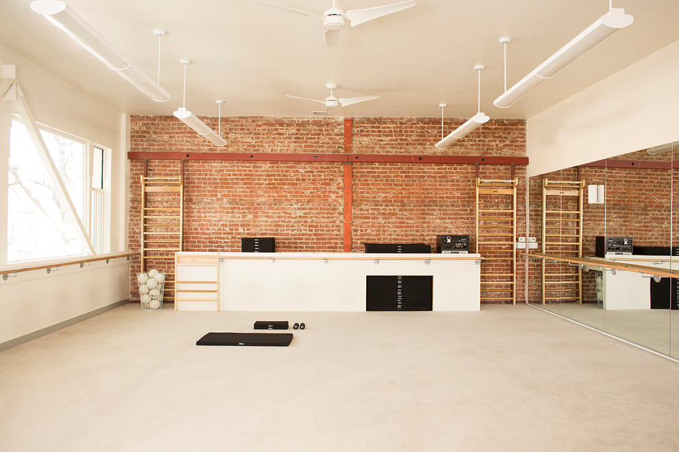 Idee per un grande studio yoga minimalista con pareti beige e moquette