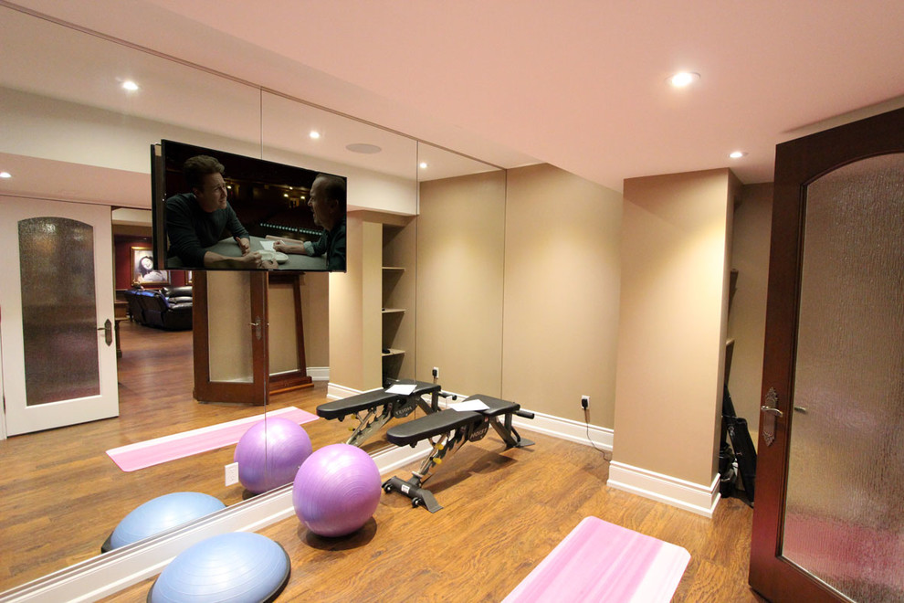 На фото: йога-студия среднего размера в классическом стиле с бежевыми стенами, полом из ламината и коричневым полом с