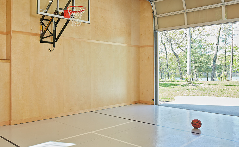 Mittelgroßer Moderner Fitnessraum mit Indoor-Sportplatz, brauner Wandfarbe, Betonboden und grauem Boden in Grand Rapids