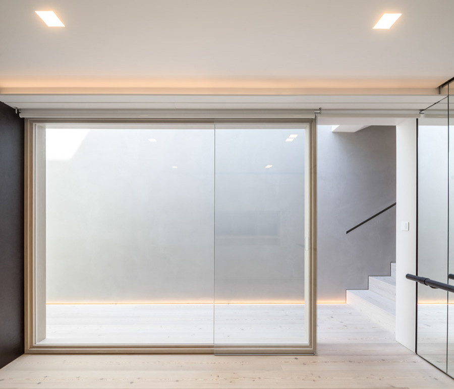 Multifunktionaler, Großer Moderner Fitnessraum mit bunten Wänden, hellem Holzboden und weißem Boden in London