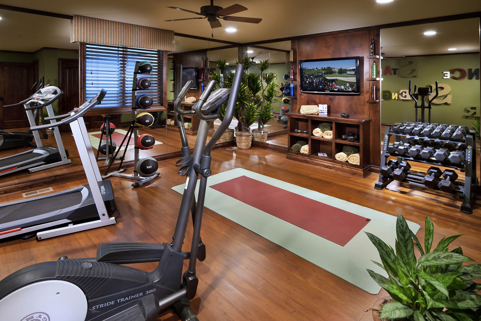 Mediterranean home gym in Denver with green walls, medium hardwood flooring and brown floors.
