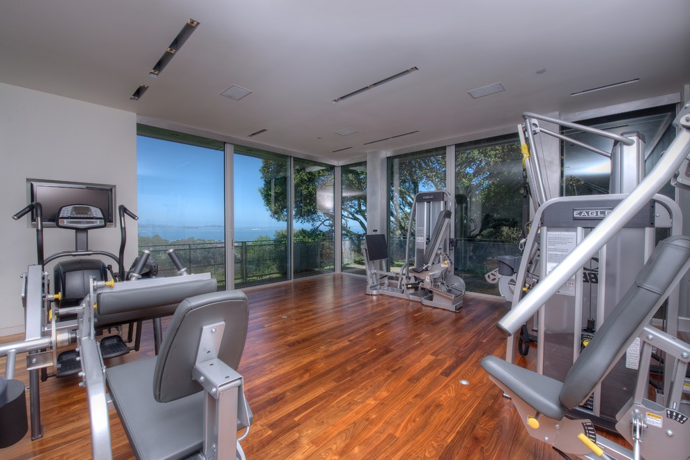 Design ideas for a contemporary multi-use home gym in San Francisco with grey walls and medium hardwood flooring.