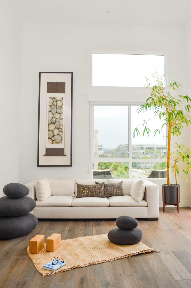 Großer Moderner Yogaraum mit weißer Wandfarbe, braunem Holzboden und grauem Boden in Los Angeles