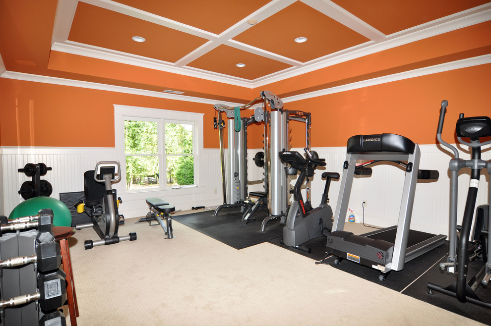 Пример оригинального дизайна: универсальный домашний тренажерный зал в классическом стиле с оранжевыми стенами и ковровым покрытием