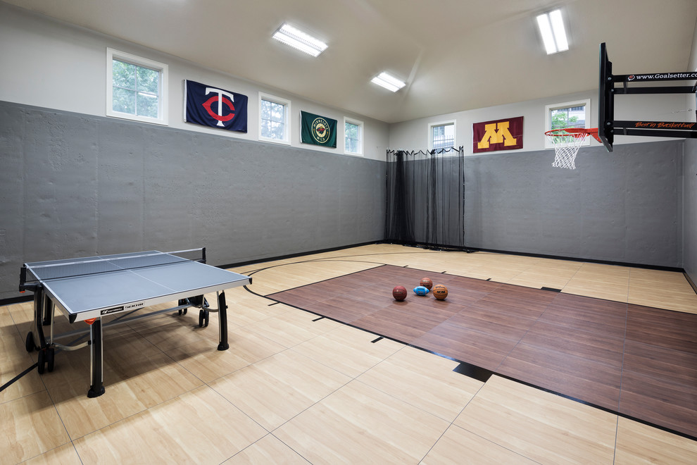 Photo of a large traditional indoor sports court in Minneapolis with beige walls, laminate floors and brown floors.