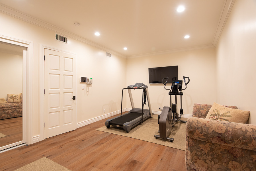 Photo of a medium sized traditional multi-use home gym in Los Angeles with white walls, medium hardwood flooring and brown floors.