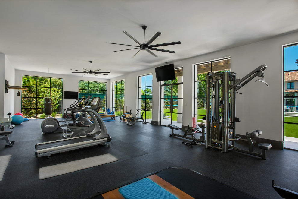 Cette image montre une salle de sport traditionnelle multi-usage avec un mur blanc et un sol noir.