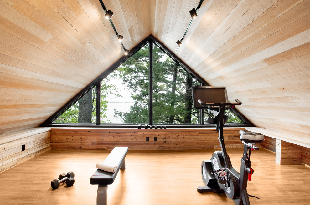 Uriger Fitnessraum mit beiger Wandfarbe, braunem Holzboden und braunem Boden in Montreal