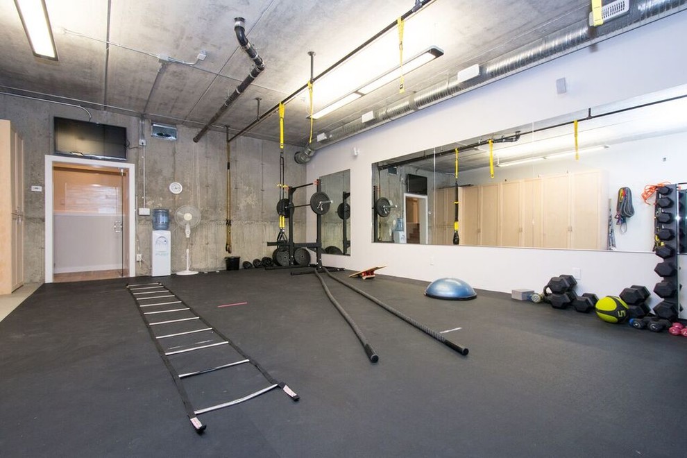 Foto de gimnasio multiusos tradicional renovado grande con paredes grises, suelo de corcho y suelo negro