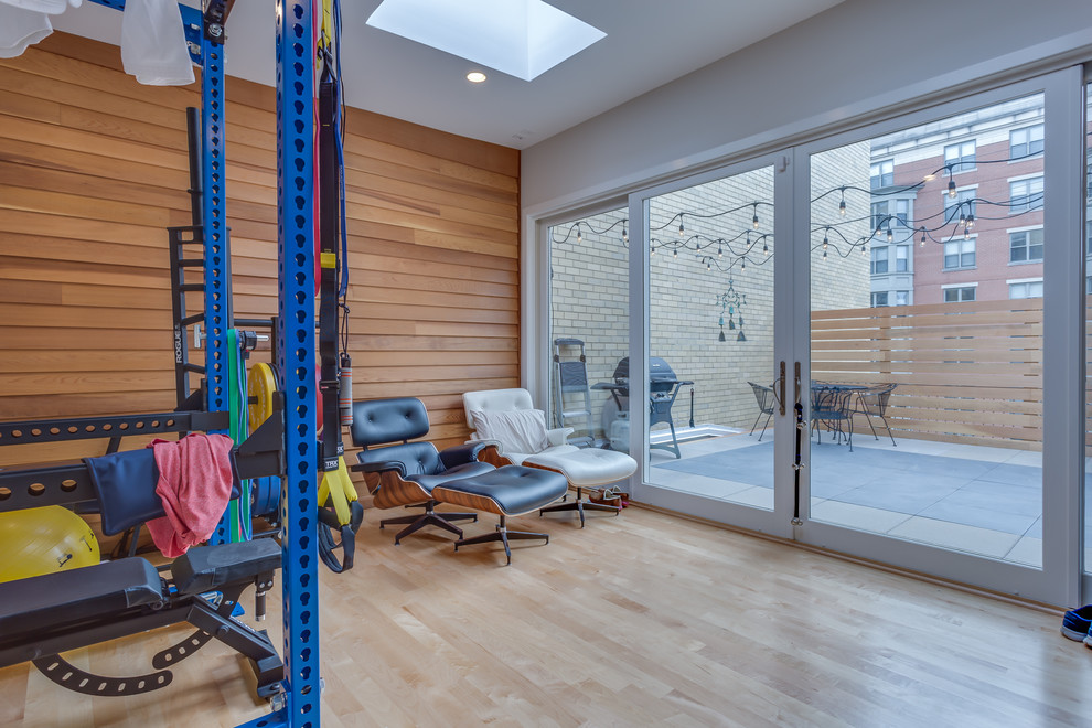 Small modern home weight room in DC Metro with white walls, light hardwood flooring and beige floors.