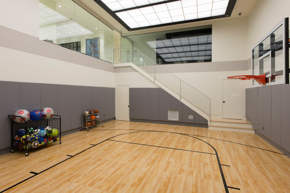 Großer Moderner Fitnessraum mit Indoor-Sportplatz, weißer Wandfarbe und hellem Holzboden in Washington, D.C.