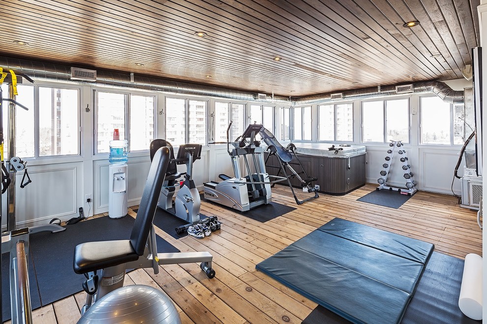 Multifunktionaler, Großer Klassischer Fitnessraum mit weißer Wandfarbe und braunem Holzboden in Toronto