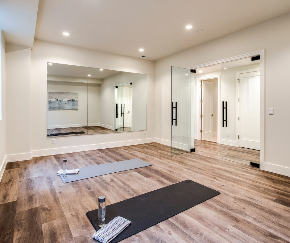 Multifunktionaler Landhaus Fitnessraum mit weißer Wandfarbe und hellem Holzboden in Denver