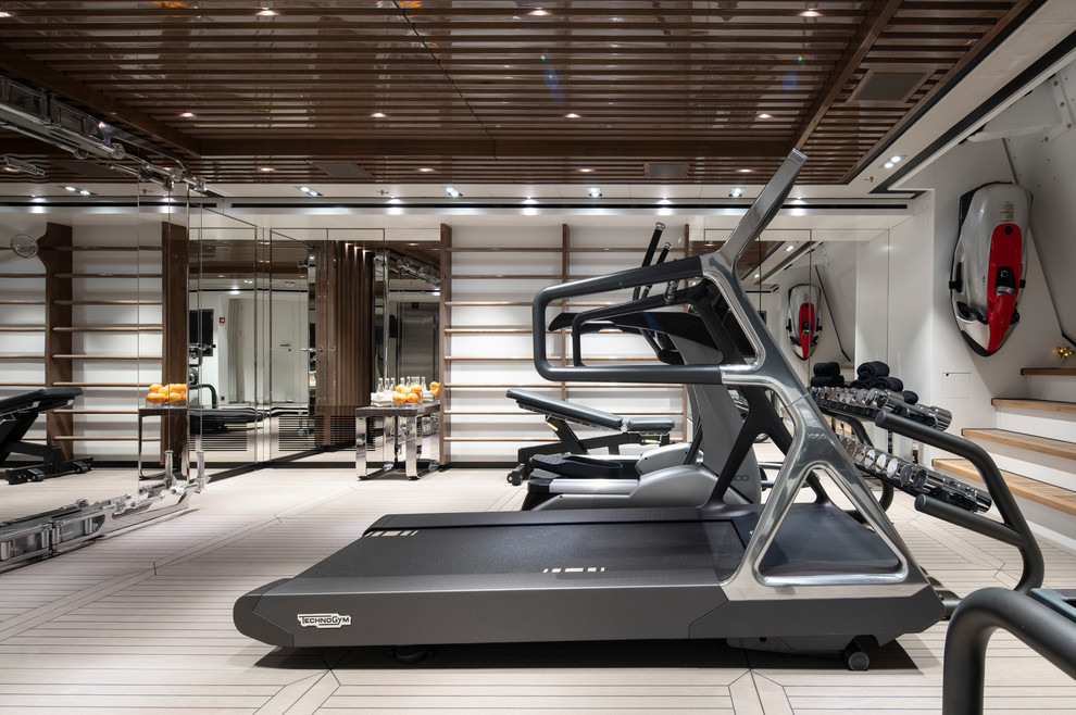Photo of a contemporary home gym in Miami with white walls, white floors and feature lighting.
