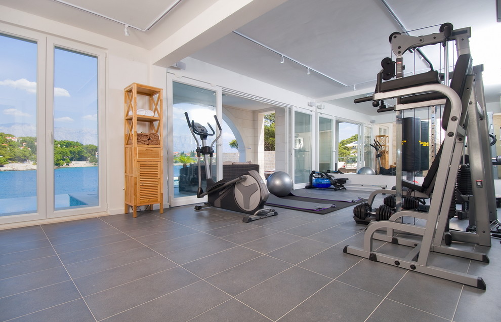 Large contemporary multi-use home gym in Other with white walls.