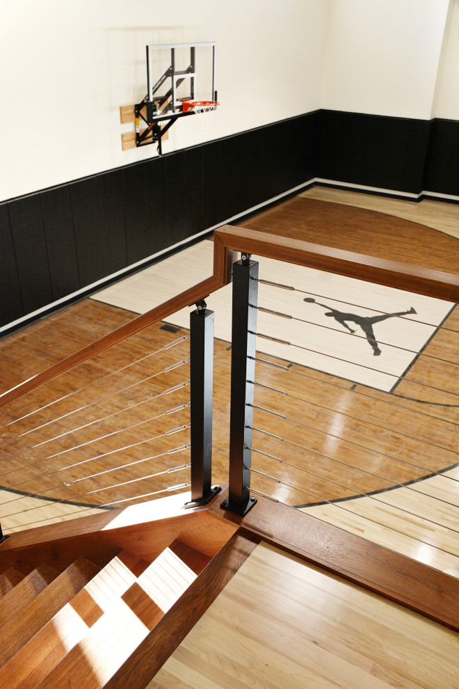 Großer Klassischer Fitnessraum mit Indoor-Sportplatz, weißer Wandfarbe, hellem Holzboden und buntem Boden in Milwaukee