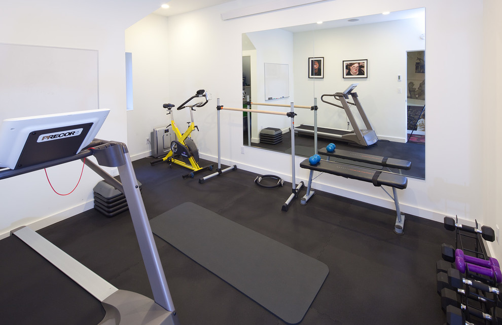 This is an example of a retro multi-use home gym in Seattle with white walls.