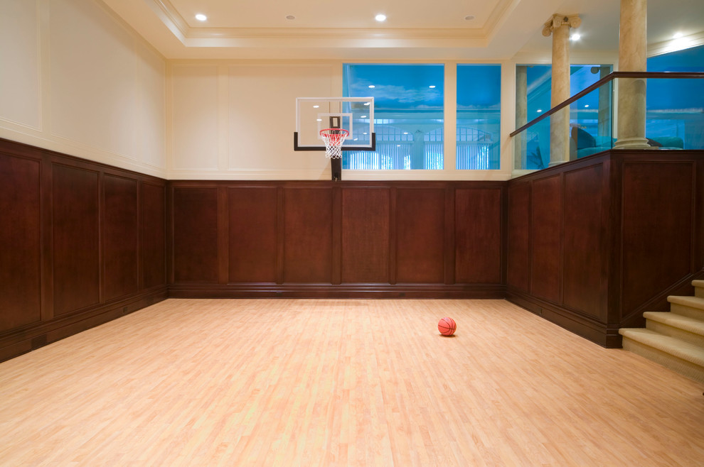 Klassischer Fitnessraum mit Indoor-Sportplatz, beiger Wandfarbe und hellem Holzboden in Detroit