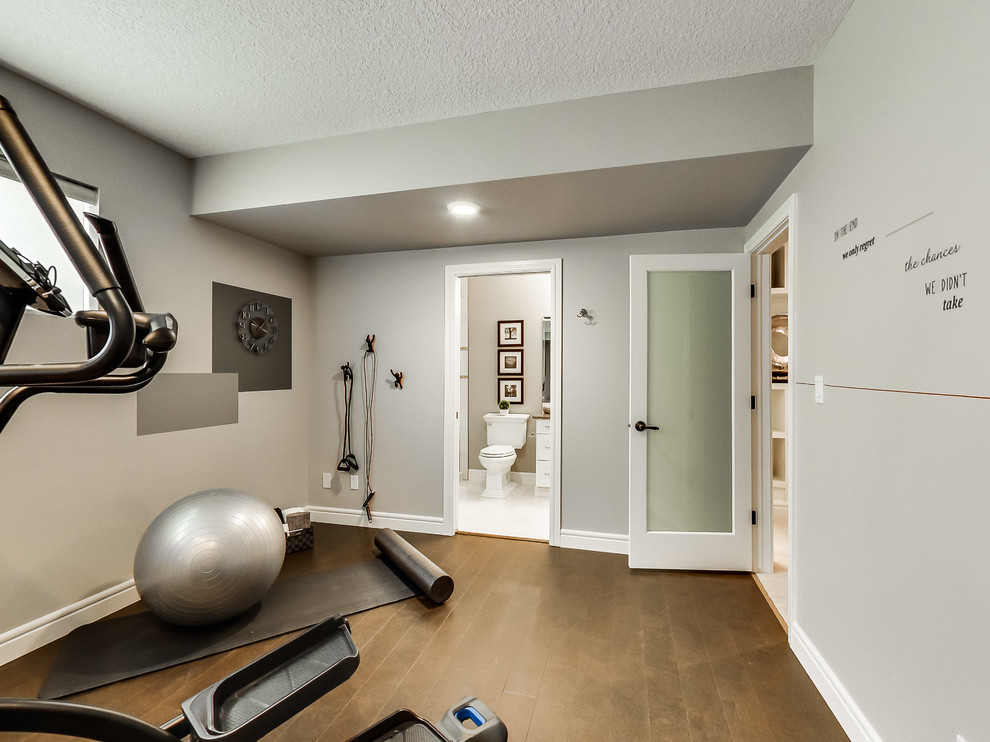 Multifunktionaler, Mittelgroßer Klassischer Fitnessraum mit grauer Wandfarbe und braunem Holzboden in Edmonton