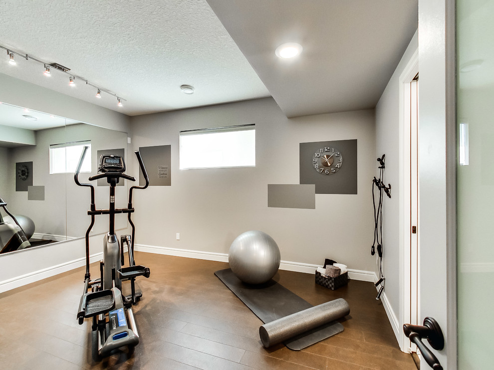 Multifunktionaler, Mittelgroßer Klassischer Fitnessraum mit grauer Wandfarbe und braunem Holzboden in Edmonton