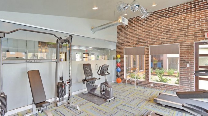 This is an example of a medium sized modern multi-use home gym in Houston with blue walls and carpet.