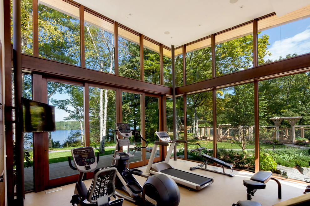 This is an example of a large contemporary home weight room in Toronto with beige floors.