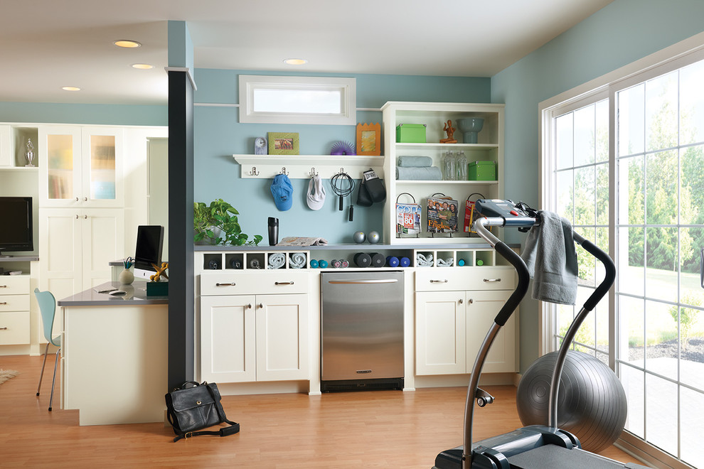 This is an example of a traditional multi-use home gym in DC Metro with blue walls and light hardwood flooring.