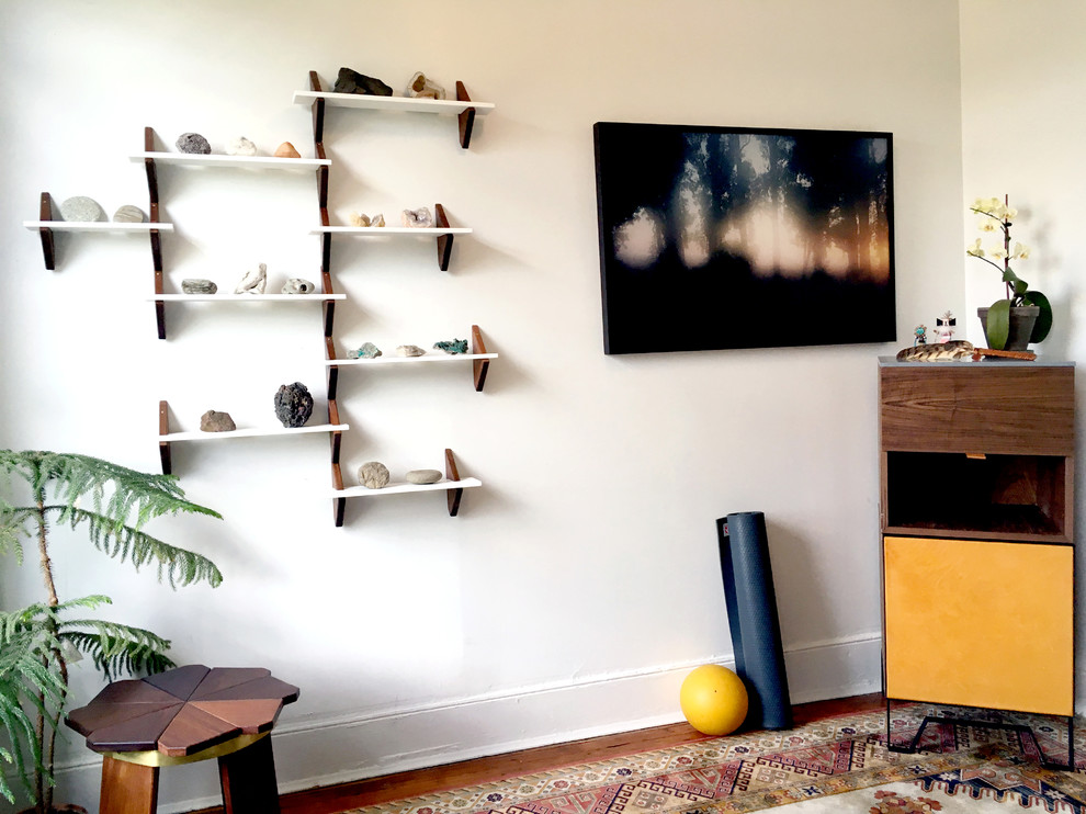 Foto di una piccola palestra in casa minimal con pareti bianche, pavimento in legno massello medio e pavimento marrone