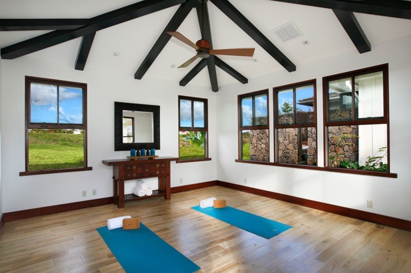 Mittelgroßer Yogaraum mit weißer Wandfarbe und hellem Holzboden in Hawaii