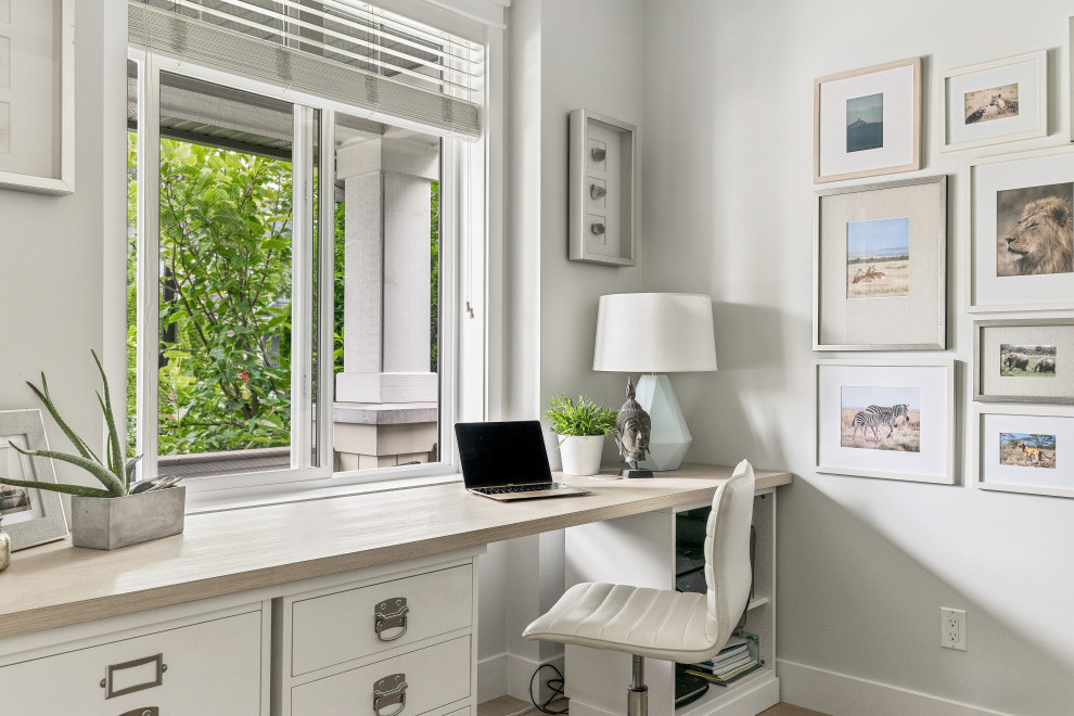 Cette image montre un bureau traditionnel avec un mur gris, un sol en bois brun, un bureau intégré et un sol marron.
