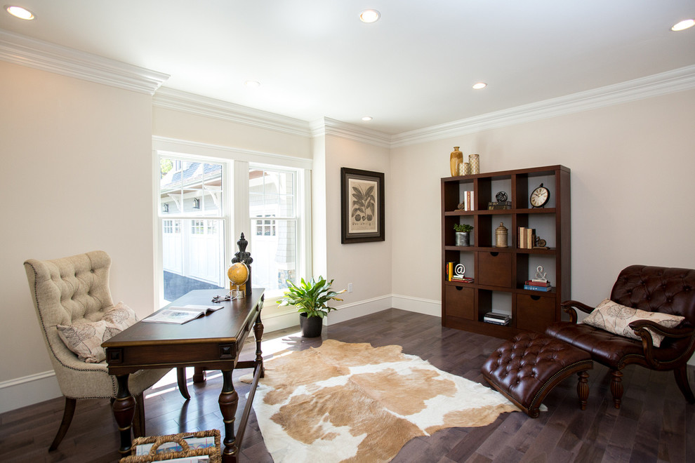 Ejemplo de despacho tradicional renovado con paredes beige, suelo de madera en tonos medios y escritorio independiente
