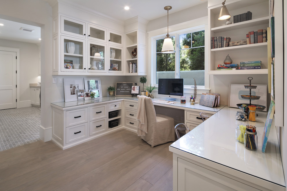Example of a transitional built-in desk medium tone wood floor and brown floor study room design in Orange County with gray walls