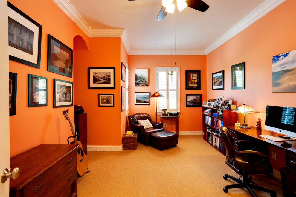 Immagine di un grande studio mediterraneo con pareti arancioni, moquette, nessun camino, scrivania autoportante e pavimento beige