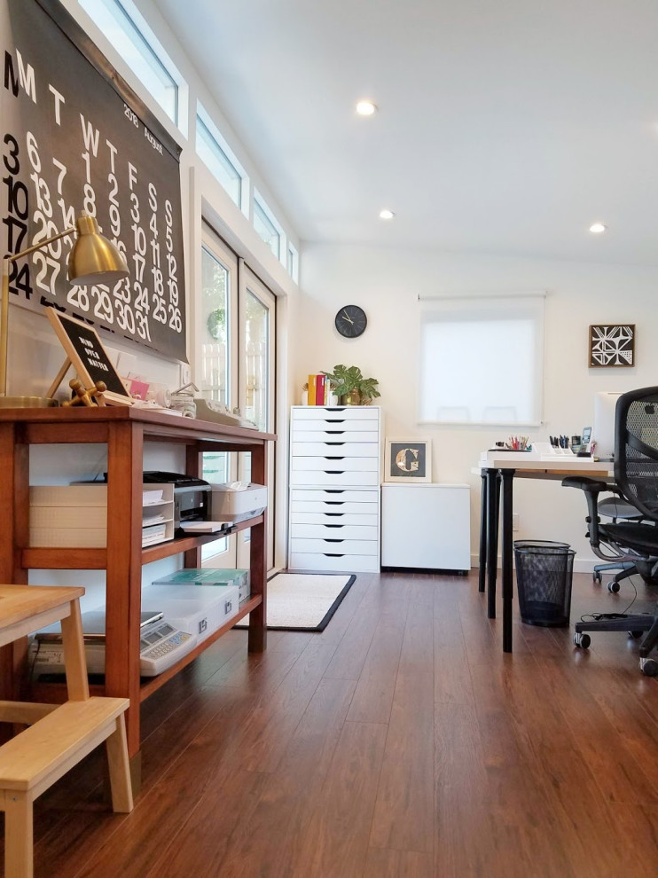 Mid-sized trendy freestanding desk dark wood floor and brown floor home studio photo in Atlanta with white walls and no fireplace