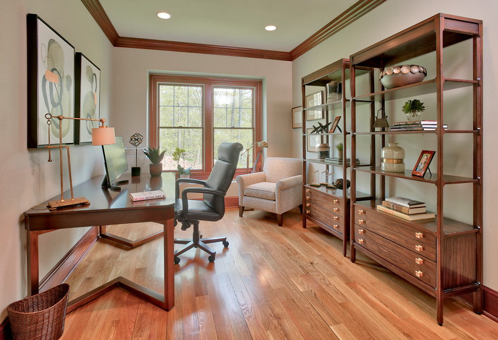 Esempio di un ufficio tradizionale di medie dimensioni con pareti beige, pavimento in legno massello medio, nessun camino, scrivania autoportante e pavimento marrone